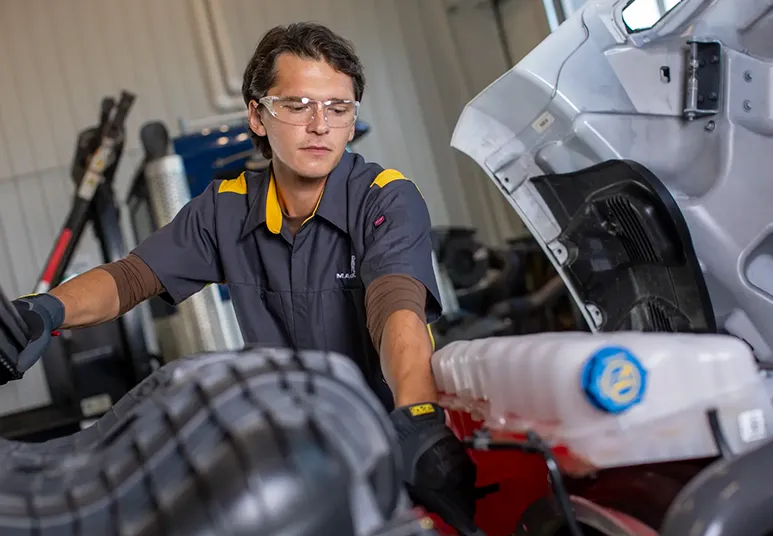 Técnico mecánico revisando el motor y sistema de refrigeración de un camión Mack Trucks en taller de Cananea, Sonora.