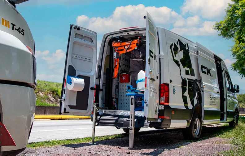 Técnico preparando equipo de asistencia desde la parte trasera de una van de servicio Mack.