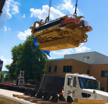 Instalación de motor Caterpillar para sistema de cogeneración industrial mediante grúa de alto tonelaje.