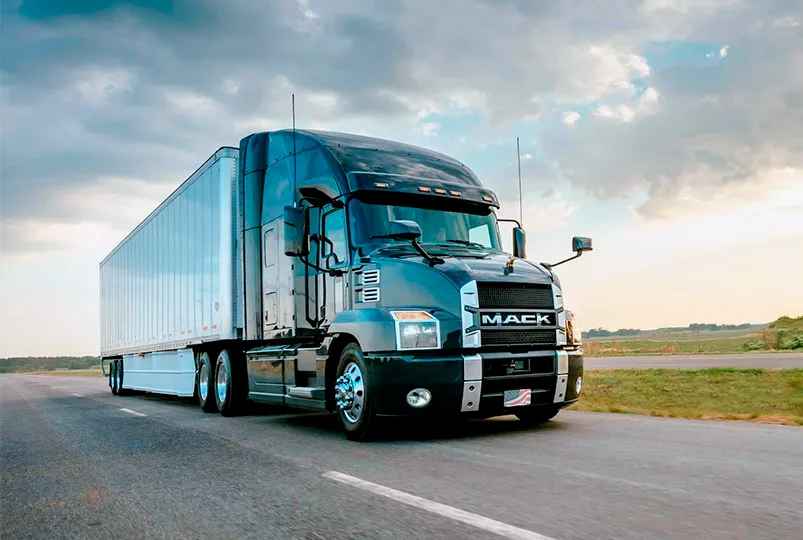 Tractocamion Mack moderno con remolque tipo caja seca circulando en carretera